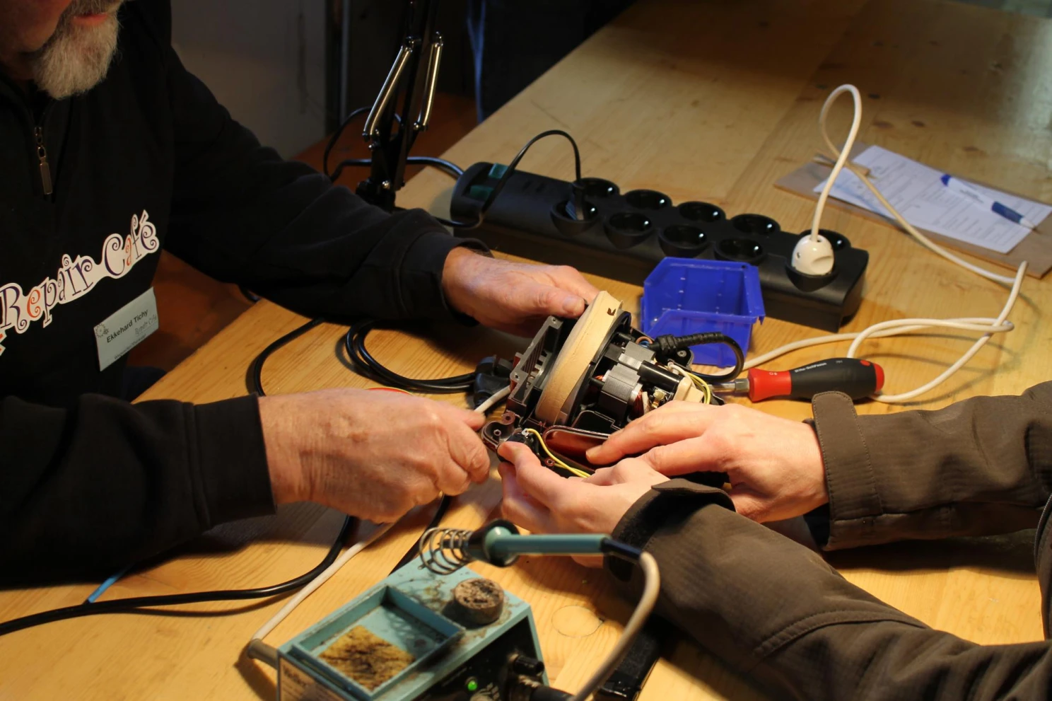 Two people working together on an electrical device at Repair Café Trier in Germany in 2015.