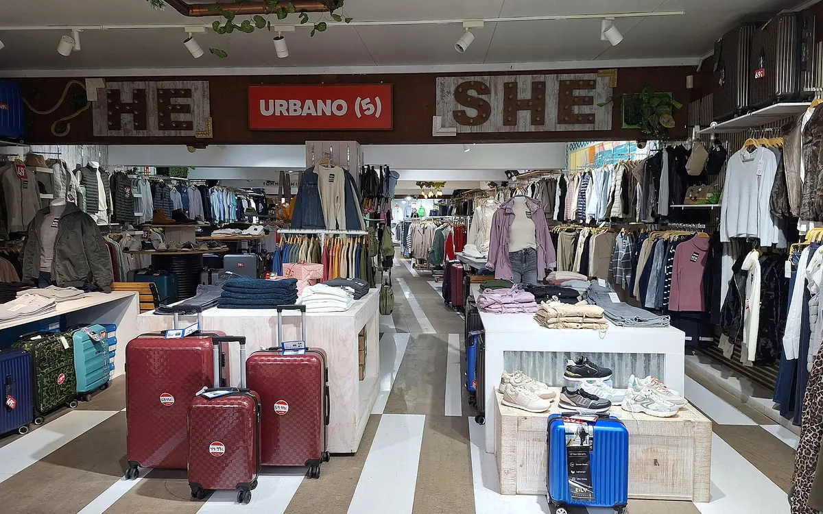 Rows of clothing and luggage inside a retail store