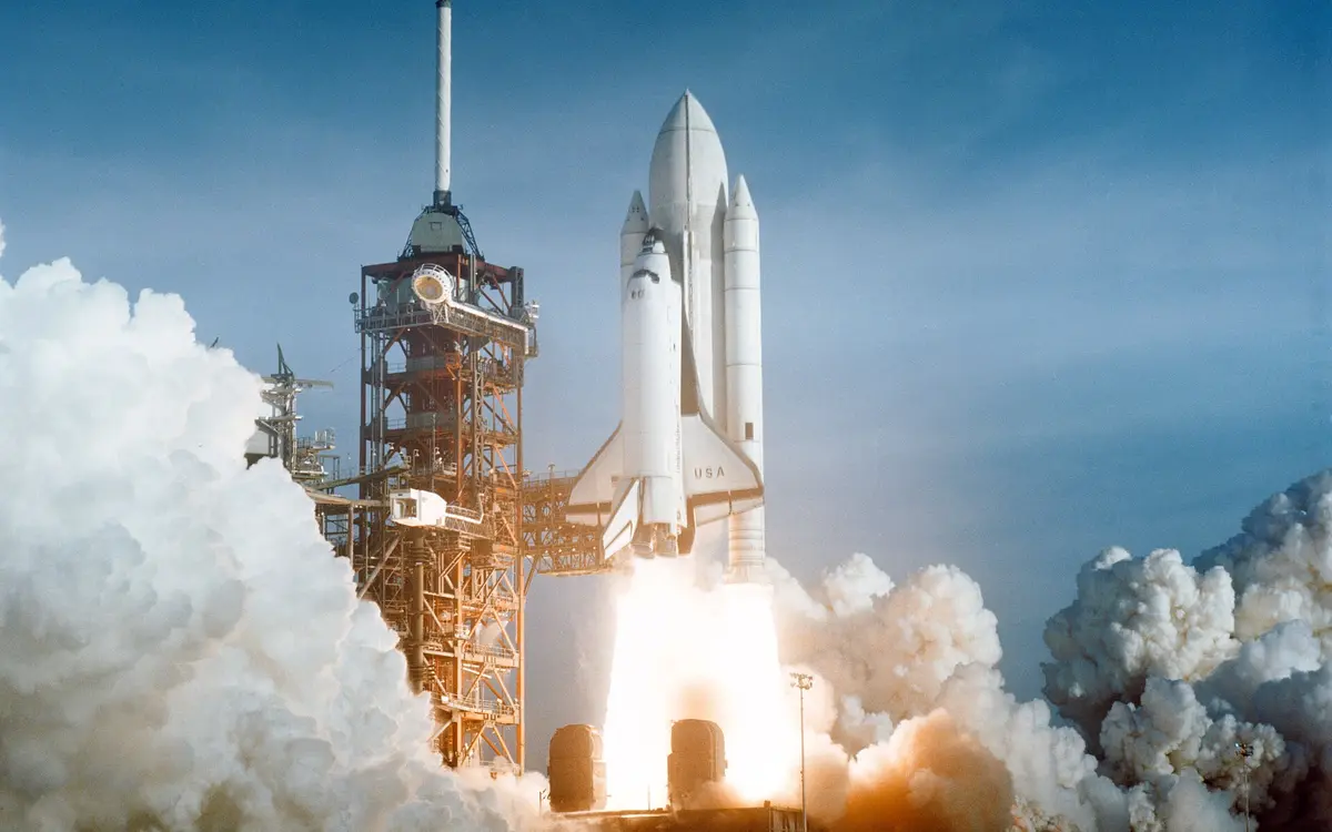 Space shuttle Columbia launching through bright clouds