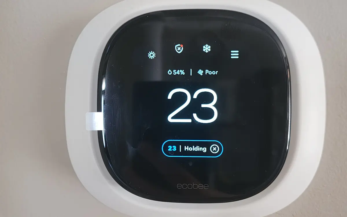 Digital smart thermostat mounted on a white wall